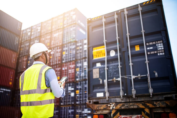 Logistics manager ensuring that containers are loaded with boxes, using insights from Logistics Management Training