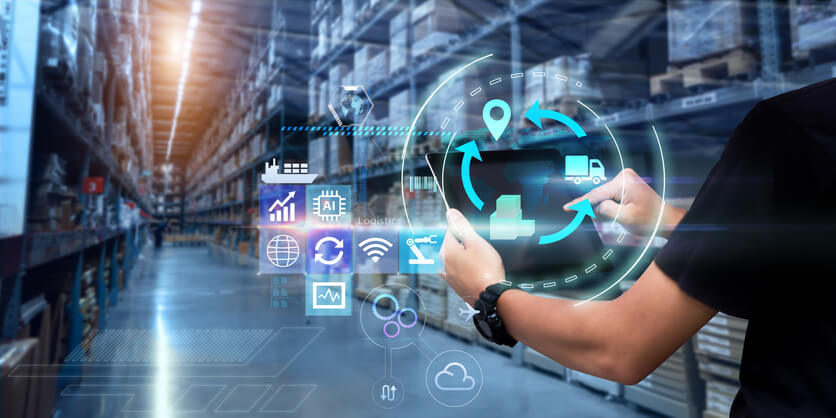 A logistics manager using modern technology at a warehouse after logistics management courses