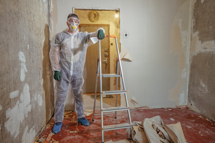 Two renovation technicians measure the dimensions of a room after home renovation training