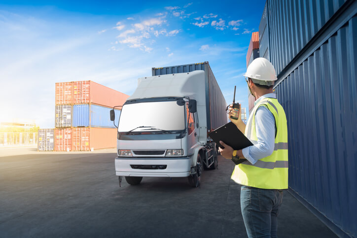 A logistics supervisor monitoring the loading of containers after their logistics training