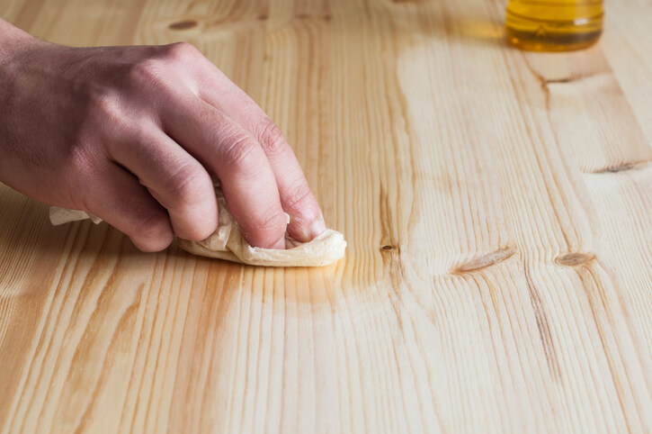 Professional home renovation technician cleaning a wooden floor surface after home renovation training