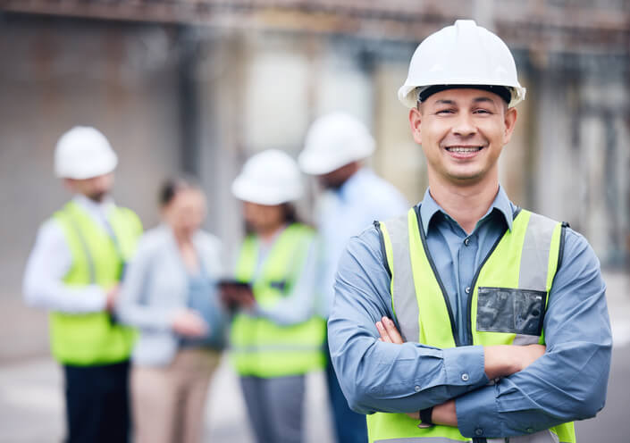 A construction worker smiles at the camera while working with his colleagues after Home Renovation Training