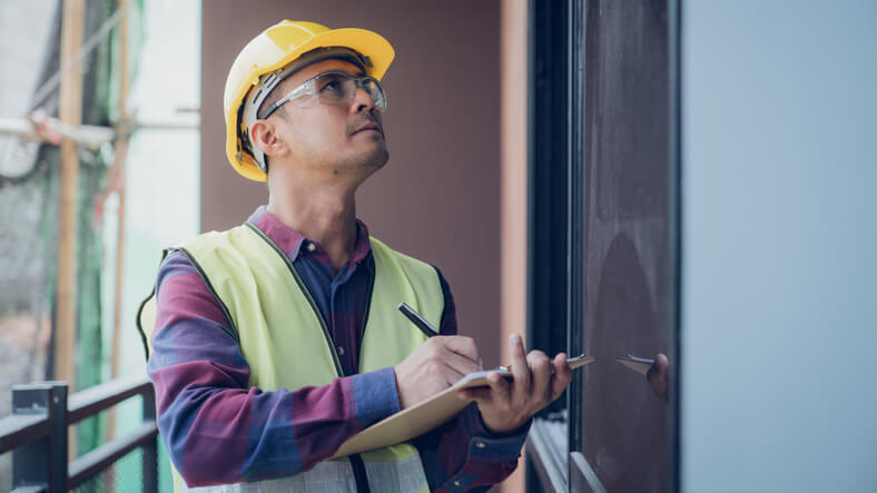 A home inspector holding a notepad after home inspection training.