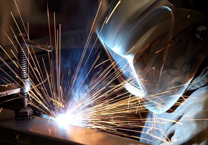 Professional welding in full protective gear working on a project after welder training