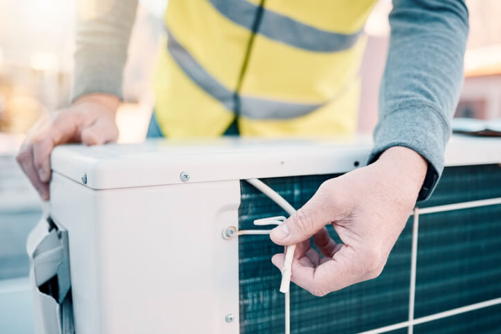 HVAC technician using his toolkit to repair a system