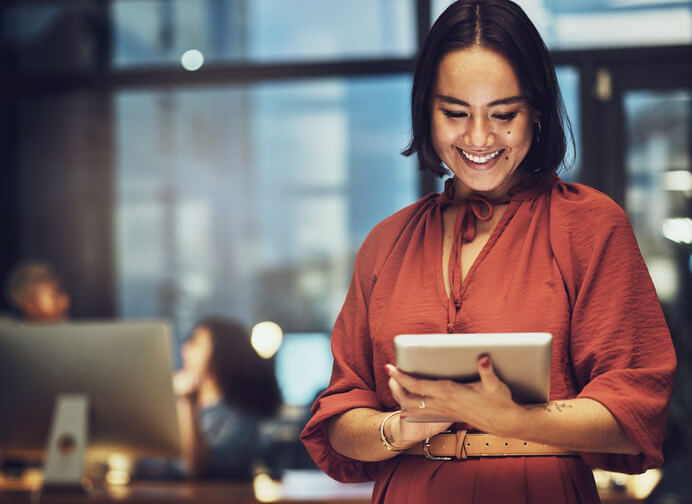 A female supply chain and logistics professional holding a tablet in an office after supply chain and logistics training