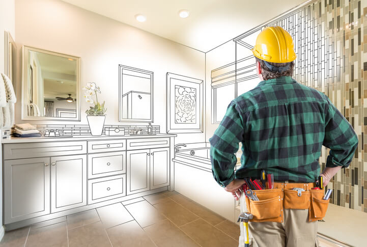 A smiling home renovation technician holding a construction plan at a work site after completing home renovation training