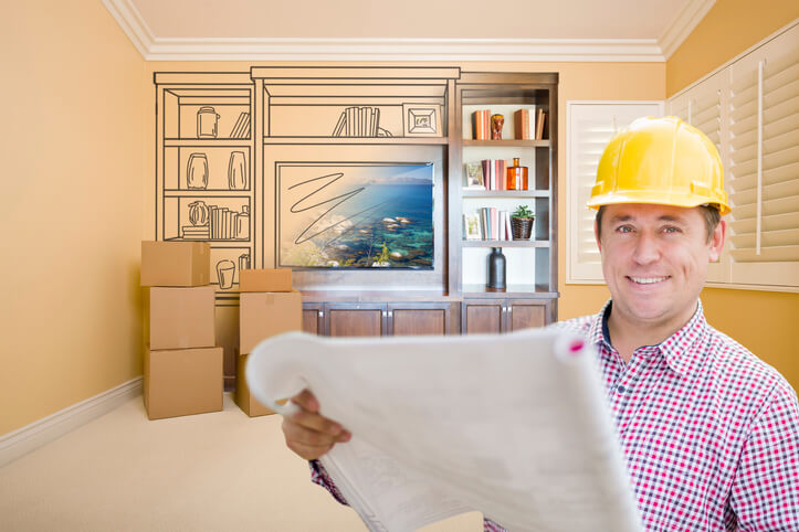 A home renovation technician assessing a renovation project after completing his home renovation training