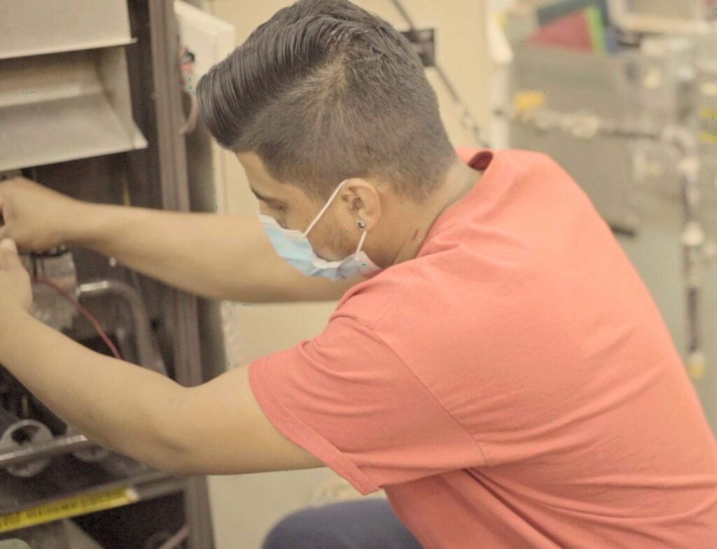 An HVAC technician working on a project after completing HVAC technician training