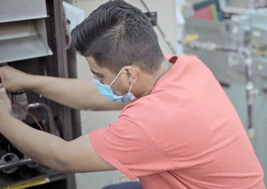 An HVAC professional working on an installation after completing HVAC technician training