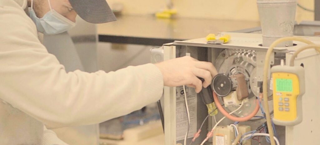 An HVAC technician examining a modern system after completing his HVAC technician training