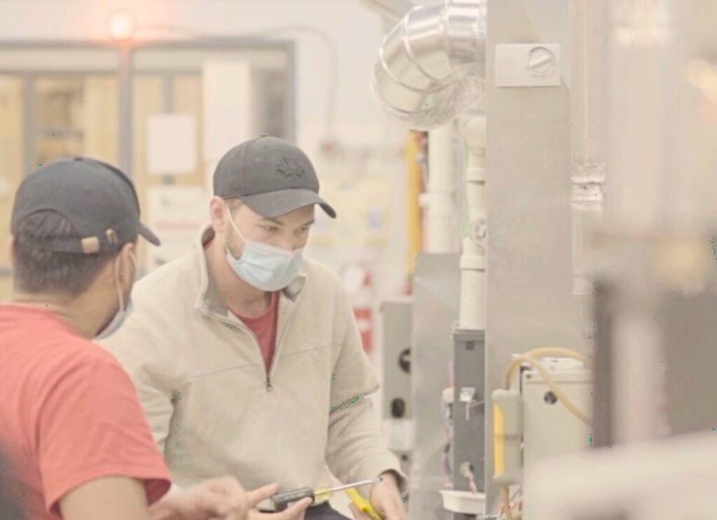 A pair of HVAC technicians troubleshooting an appliance after HVAC technician training